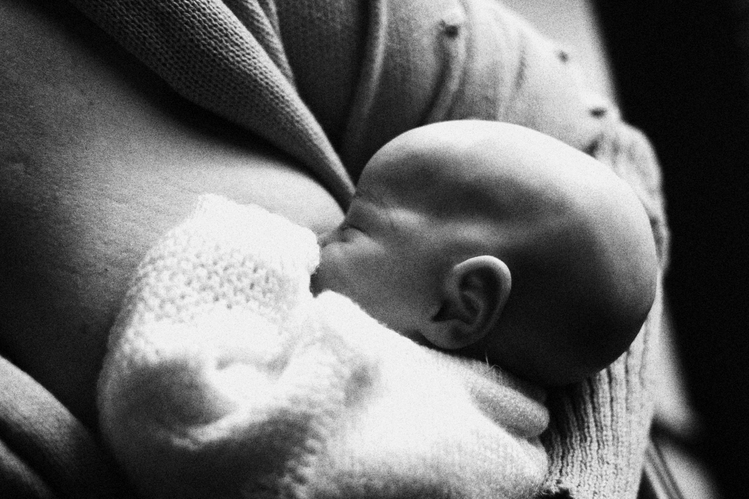 A heartwarming black and white image of a mother breastfeeding her baby, capturing tenderness and bonding.