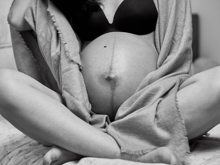 Artistic black and white maternity photo showing a pregnant woman's belly.